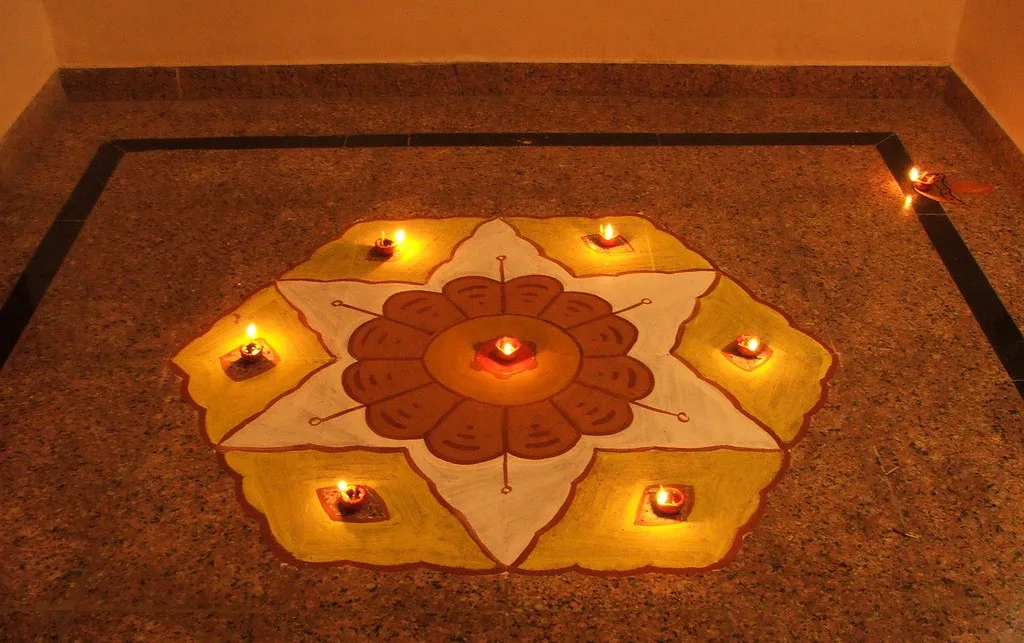 Rangoli with lit diyas in front of a door for Diwali